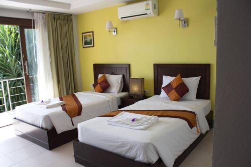 a hotel room with two beds and a balcony at Koh Kwang Seaview in Klong Muang Beach