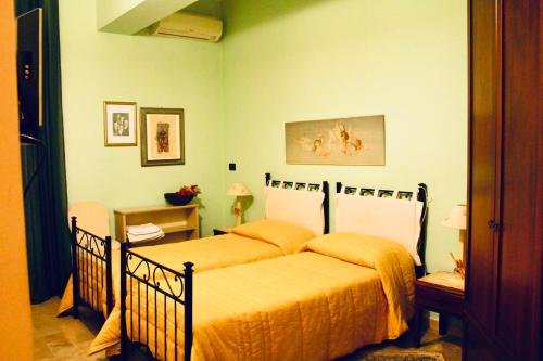 A Casa Di Mamma في ميلاتسو: سريرين في غرفة نوم مع جدران خضراء