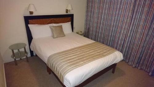 a bed in a hotel room with a large white bed at Coventry Hill Hotel in Coventry