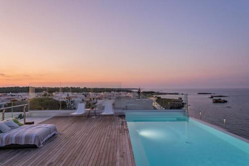 a swimming pool on the roof of a house with the ocean at Posia Retreat & Spa UNA Esperienze in San Foca