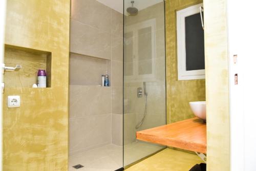 La salle de bains est pourvue d'une douche en verre et d'un lavabo. dans l'établissement Central apartment at Echarxia 2 beds for 5 pers, à Athènes