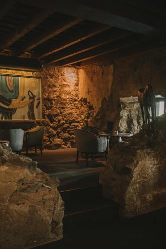 a room with chairs and a table in a stone wall at Hotel Museo Spa Casa Santo Domingo in Antigua Guatemala