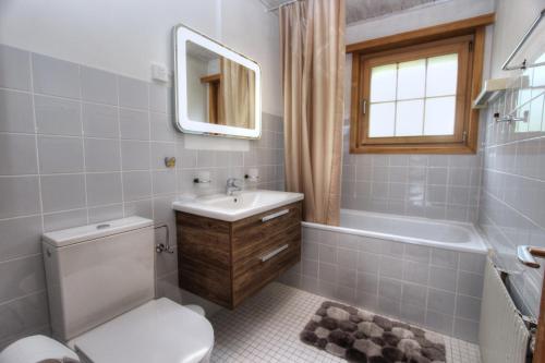un bagno con un water, un lavandino e una vasca di Appartement Le Roc a Gstaad