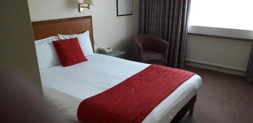 a hotel room with a bed and a chair at Coventry Hill Hotel in Coventry