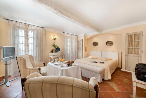 una camera con letto, tavolo e sedie di Bastide Saint Antoine - Relais & Châteaux a Grasse