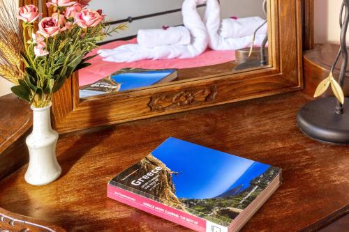a table with a mirror and a book on a table at Hotel PARALIAKO Kyparissi in Kyparíssion