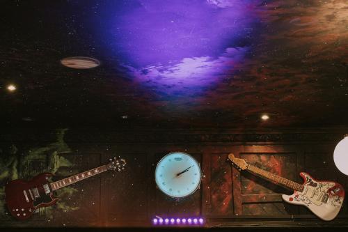 two guitars and a clock in a room with a ceiling at The Saddle Inn in Chester