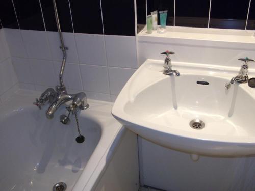 W łazience znajduje się umywalka i wanna. w obiekcie Coventry Hill Hotel w Coventry