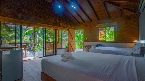 Boca Tapada Lodge في Boca Tapada: غرفة نوم بسريرين وشرفة