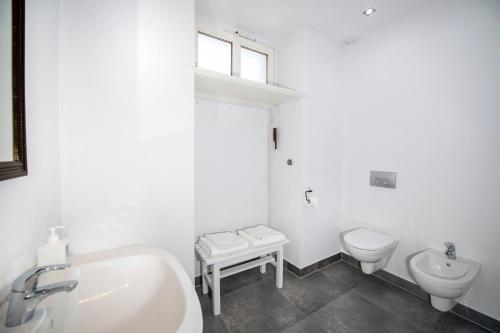 Baño blanco con lavabo y aseo en Apartament Villa Clara, en Lądek-Zdrój