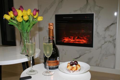 a table with a bottle of champagne and a vase of flowers at Spa Panorama in Belgrade