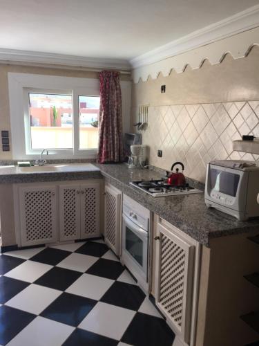 a kitchen with a checkered floor at Europa mirlef t aventur Guest House in Mirleft