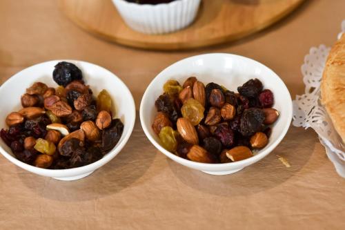 two bowls of nuts and raisins on a table at Bernie's Bed & Breakfast , A 3 KILOMETROS DEL AEROP EZEIZA, VAN ,IN-OUT, FREE EZEIZA AIRPORT in Ezeiza