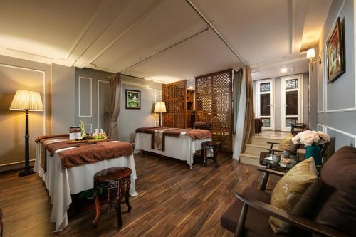 una camera d'albergo con due letti e un divano di Hong Ngoc Dynastie Boutique Hotel & Spa a Hanoi