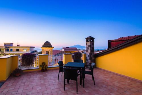 a patio with a table and chairs on a balcony at Sine Tempore in Sorrento