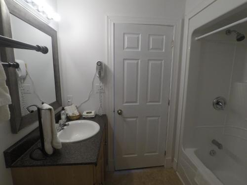 a bathroom with a sink and a white door at Wood Duck Cottage in Cavendish