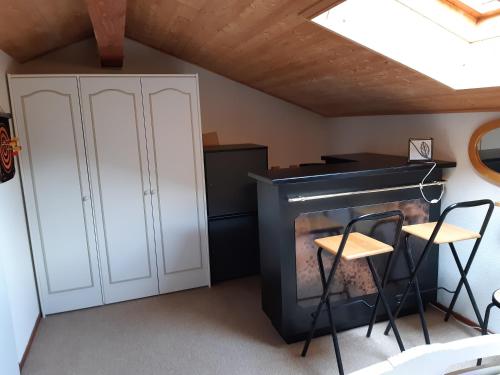 un salon avec une cheminée et deux tabourets dans l'établissement MBS e16, à Manigod