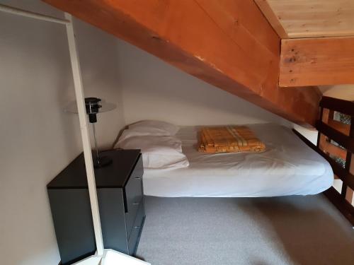 une petite chambre avec un lit dans un grenier dans l'établissement MBS e16, à Manigod