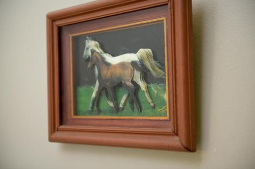 a painting of a horse in a frame on a wall at Bernie's Bed & Breakfast , A 3 KILOMETROS DEL AEROP EZEIZA, VAN ,IN-OUT, FREE EZEIZA AIRPORT in Ezeiza