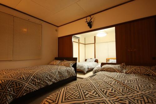 1 dormitorio con 2 camas y espejo en 札幌ドーム前ハウス Sapporodome front house en Sapporo