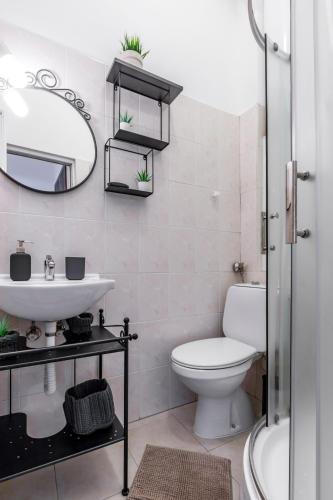 Un baño con inodoro, lavabo y espejo. en Apartment 11, en Sofía