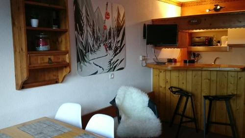 a kitchen with a table and a bar with stools at Bourg St Maurice les Arcs 1800 Les Lauzieres jolie vue, nature, espace, bien être, plaisir, paisible in Arc 1800