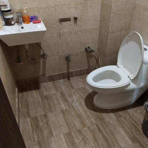 a bathroom with a toilet and a sink at Sprinklers in New Delhi