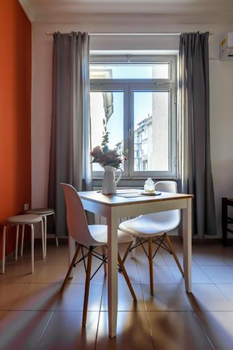 Una mesa de comedor con dos sillas y una ventana. en Apartment 11, en Sofía