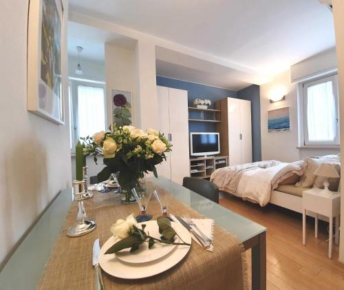 Corso Vercelli Apartment في ميلانو: غرفة معيشة مع طاولة مع إناء من الزهور