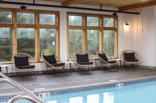 eine Gruppe von Stühlen, die um einen Tisch neben einem Pool herum sitzen in der Unterkunft Adrift Hotel in Long Beach