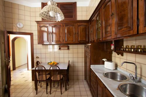 a kitchen with wooden cabinets and a table with chairs at Sine Tempore in Sorrento