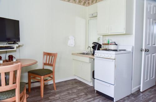 a kitchen with a refrigerator, stove, microwave and a table at Friendship Oceanfront Suites in Old Orchard Beach