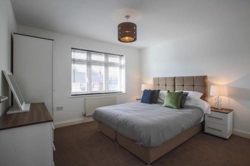 a bedroom with a bed and a window and a television at Vale House in Northfleet