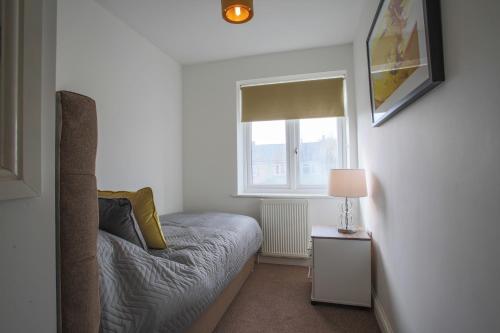 a small bedroom with a bed and a window at Vale House in Northfleet