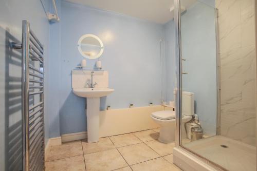 een badkamer met een toilet, een wastafel en een douche bij Vale House in Northfleet