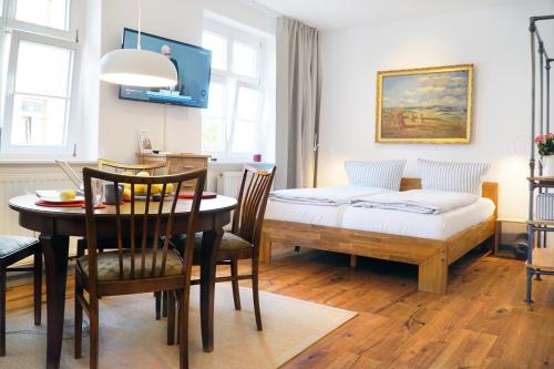 薩勒河畔瑙姆堡的住宿－Apartment Dompredigergasse，客厅配有餐桌和1张床