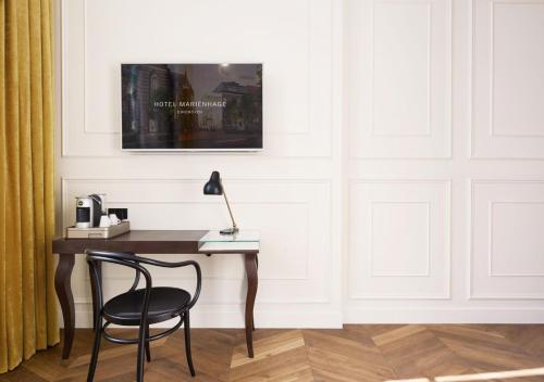 a desk with a chair and a lamp in a room at Hotel Mariënhage in Eindhoven