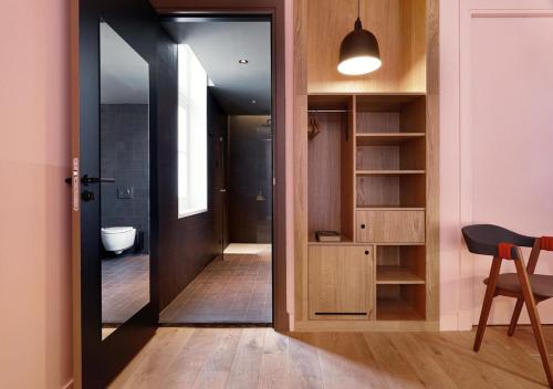 a bathroom with a door open to a bathroom with a toilet at Hotel Mariënhage in Eindhoven