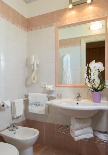 a bathroom with a sink and a toilet and a mirror at Hotel Globus in Bellaria-Igea Marina