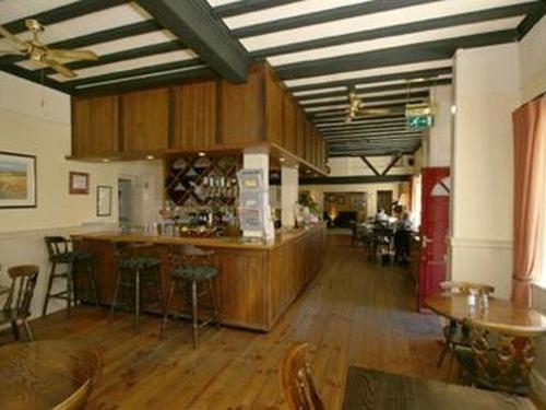 uma grande sala com um bar e algumas mesas e cadeiras em Bolingbroke Arms & Hotel em Swindon