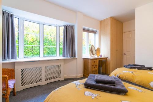a bedroom with two beds and a window at The Garden Apartment in Bramhall