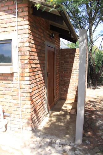 a brick building with a door and a window at Casa Cara Resort in Parys