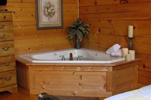 Cette chambre dispose d'une baignoire et d'un mur en bois. dans l'établissement #2903 Abundantly Blessed, à Pigeon Forge