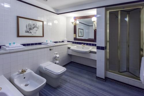 y baño con aseo, lavabo y ducha. en Europa Gatwick Hotel & Spa en Crawley