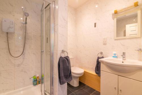 a bathroom with a shower and a toilet and a sink at The Garden Apartment in Bramhall