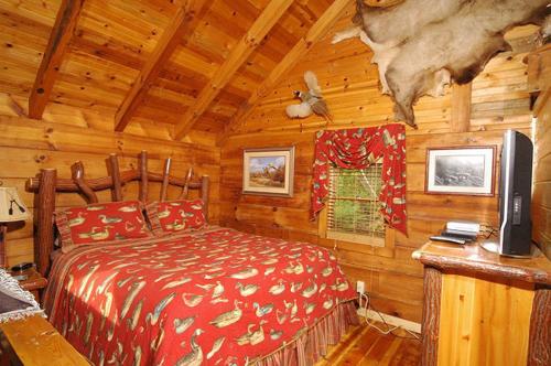 a bedroom with a bed in a log cabin at #754 Bear Hugs in Gatlinburg