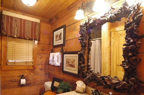 a bathroom with a mirror and a wooden wall at #754 Bear Hugs in Gatlinburg