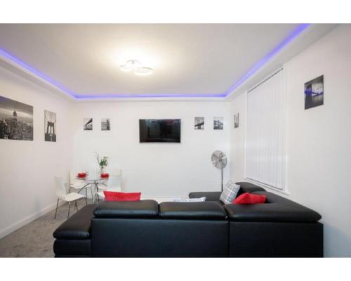 a living room with a black couch and red pillows at CARTER HOUSE APARTMENTS.....6 beds in 3 bedrooms in Leeds