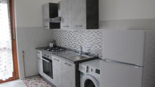a small kitchen with a sink and a refrigerator at LA SISTEMAZIONE BRILLANTINO GOLD in Rozzano