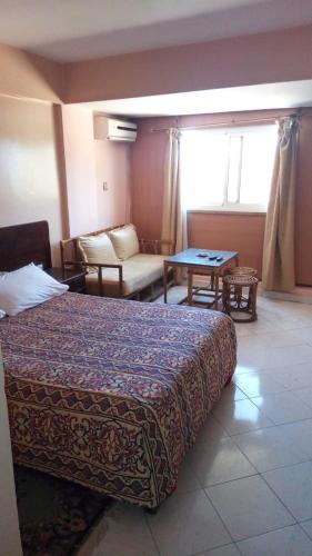 ein Hotelzimmer mit einem Bett und einem Tisch in der Unterkunft Hôtel chahrazad in Imouzzer du Kandar